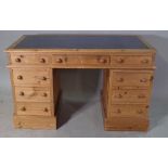 A 20th century pine pedestal desk with blue leather inset top, 132cm wide x 74cm high.