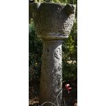 An Istrian carved stone font, 18th century, with four lion mask handles, carved meandering border,