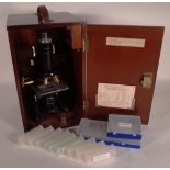 A 20th century Watson service microscope, cased and slides.