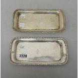 A near pair of George III silver candle snuffer's trays, of rounded rectangular form,