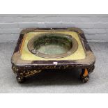 A 19th century Chinese export brass and black lacquer brazier on four splat supports,