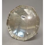 A silver salver of shaped circular form, with a raised rim, on four pad feet, Sheffield 1942,