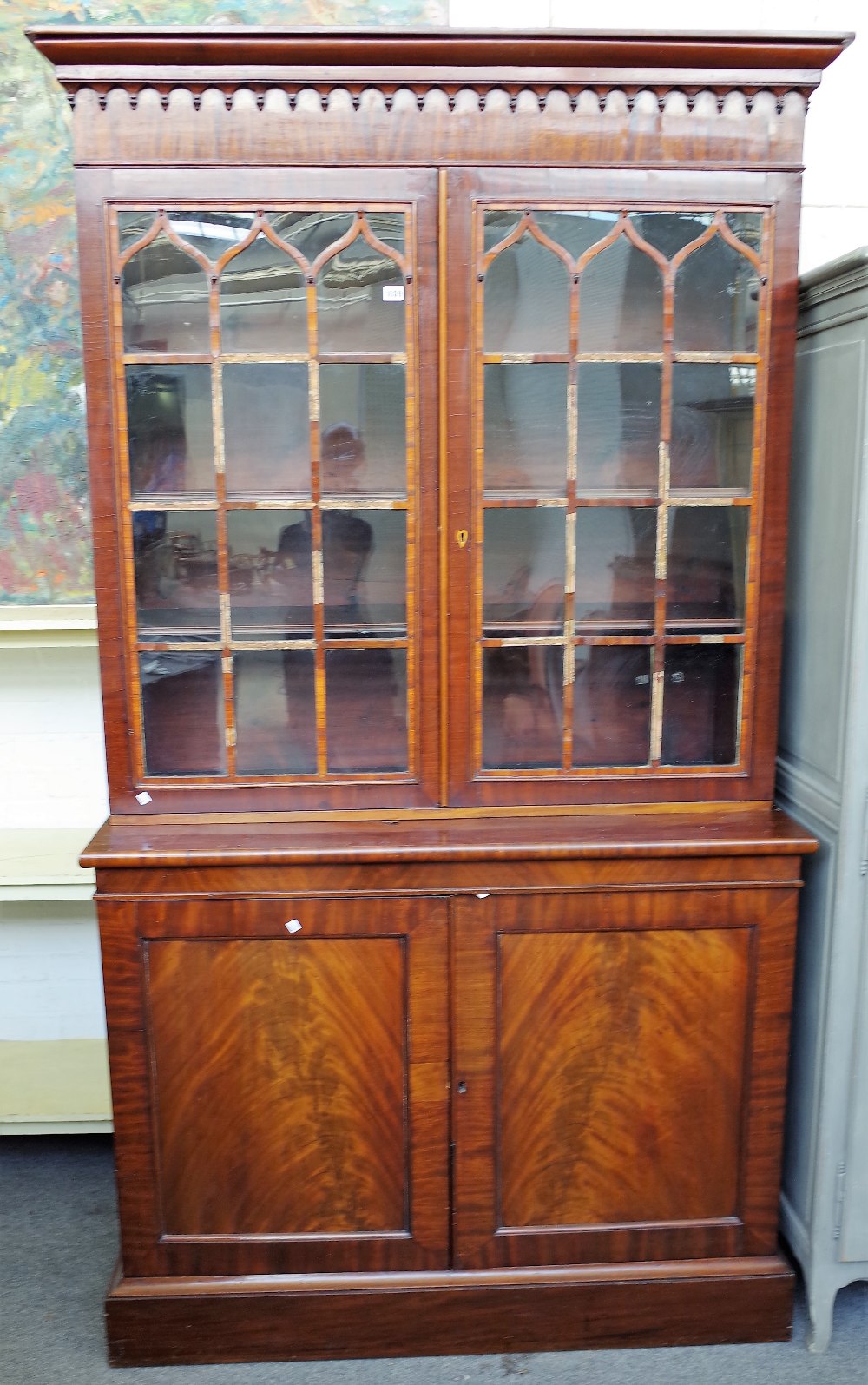 A mahogany library bookcase, Regency top on associated base,