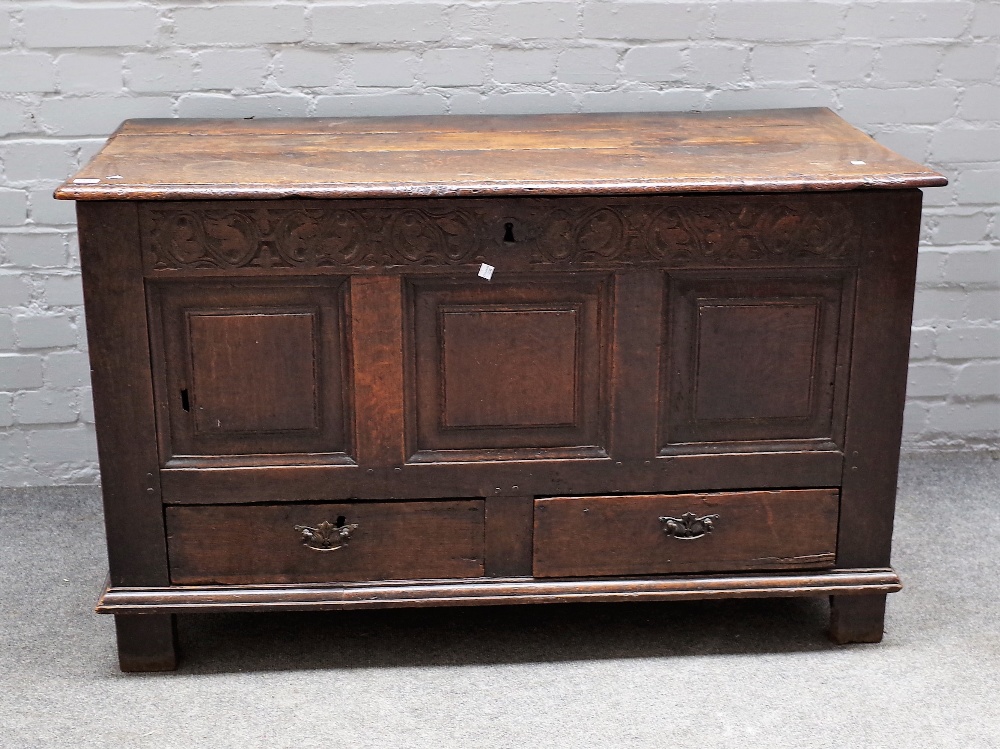 An 18th century oak mule chest, the lift top over triple panel front and pair of drawers,