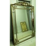 A large 20th century silver painted marginal wall mirror with carved crest and bevelled plate,