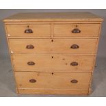 An early 20th century pine chest of two short and three long graduated drawers,