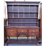 A mid-18th century oak dresser, the enclosed three tier plate rack over five frieze drawers,