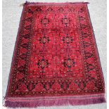 Two similar Afghan Beluche rugs, each with madder fields, one with two square sections,