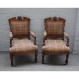 A pair of late French walnut framed open armchairs,