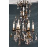 A modern six branch gilt metal and glass chandelier of open form with foliate moulded glass leaves