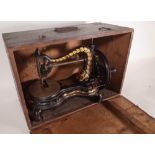 A Jones serpentine sewing machine within a stained pine case.