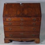 A late George III walnut and mixed wood bureau with fitted and welled interior,