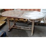 A teak rectangular extending garden table of slatted construction,