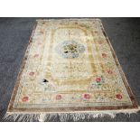 A Chinese silk rug, the ivory field with a central floral bouquet,