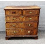 A George I figured walnut and burr yew chest, with two short and three long graduated drawers,