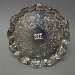 A Victorian silver salver of shaped circular form, having a shell capped pie-crust border,