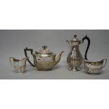 A silver composite four piece tea set, comprising; an oval teapot, with black composition fittings,