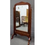 A 19th century pitch pine cheval mirror, with bevelled plate on canted block supports,