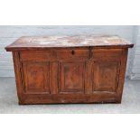 A 17th century French elm coffer, the plank top over carved triple panel front, dated 1690,