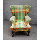 A George II style wingback armchair, on claw and ball feet, 85cm wide x 105cm high.