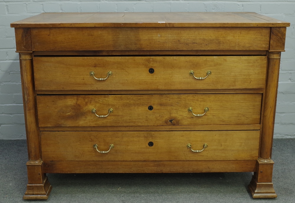 A 19th century fruitwood commode of four long drawers flanked by turned columns,