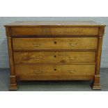 A 19th century fruitwood commode of four long drawers flanked by turned columns,