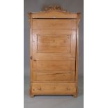 An early 20th century arch top pine single door wardrobe, with single drawer to base on bun feet,