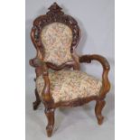 A late 19th century continental oak open armchair with carved crest on cabriole supports.