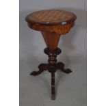 A late Victorian mahogany and satinwood inlaid circular games/sewing table on three downswept