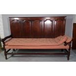 An 18th century oak settle with five panel back on block and turned supports,