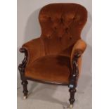 A Victorian mahogany framed armchair with brown button back upholstery.