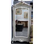 An 18th century style French wardrobe, with scroll crest over bevelled mirror door,