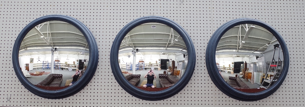 A set of three 20th century convex wall mirrors in blue painted moulded frames, 64cm diameter.