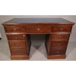 An early 20th century mahogany pedestal desk with tooled faux blue leather inset top,