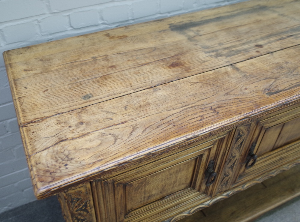 A 17th century style carved oak dresser base, with three recessed panel doors, on turned supports, - Image 3 of 5