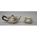 A silver teapot, of compressed circular form, with fluted decoration,
