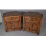 A pair of 20th century oak side cabinets, with two drawers over cupboard base,