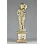 A reconstituted stone figure of a cherub or young Bacchus in standing pose entwined with grapes and