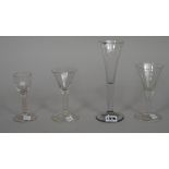 Four plain-stemmed wine glasses, mid 18th century, comprising; a tall glass with drawn trumpet bowl,