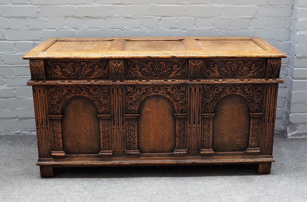 A 17th century style oak coffer, with triple panel lid and front, on stile feet,