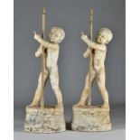 A pair of white painted cast metal figures of standing boys on oval scroll bases, possibly French,