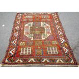 A Karachov rug, Caucasian, the madder field with a bold ivory medallion, squared motifs at each end,