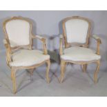 A pair of Louis XV style beech framed open armchairs, with serpentine seat on cabriole supports,