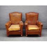 A pair of 20th century French leather upholstered club chairs on shaped beech supports,