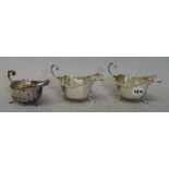 A pair of George V silver sauceboats, with wavy rims and raised on three pad feet,
