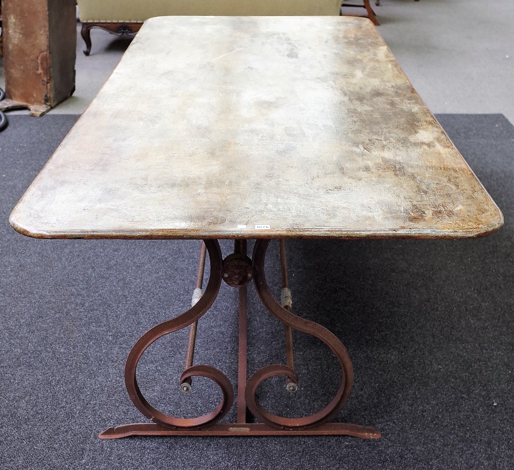 A 20th century sheet and wrought iron rectangular garden table, on trestle end supports,