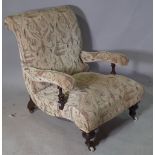 A Victorian mahogany framed low open armchair on ring turned tapering supports.