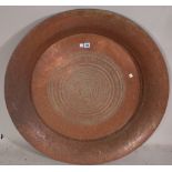 A large copper charger , late 19th century possibly Indian with foliate engraved decoration,