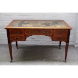 A late Victorian inlaid mahogany writing table with five frieze drawers on tapering square supports,