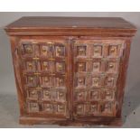A 20th century Indian hardwood side cabinet with studded panelled doors, 107cm wide x 102cm high.